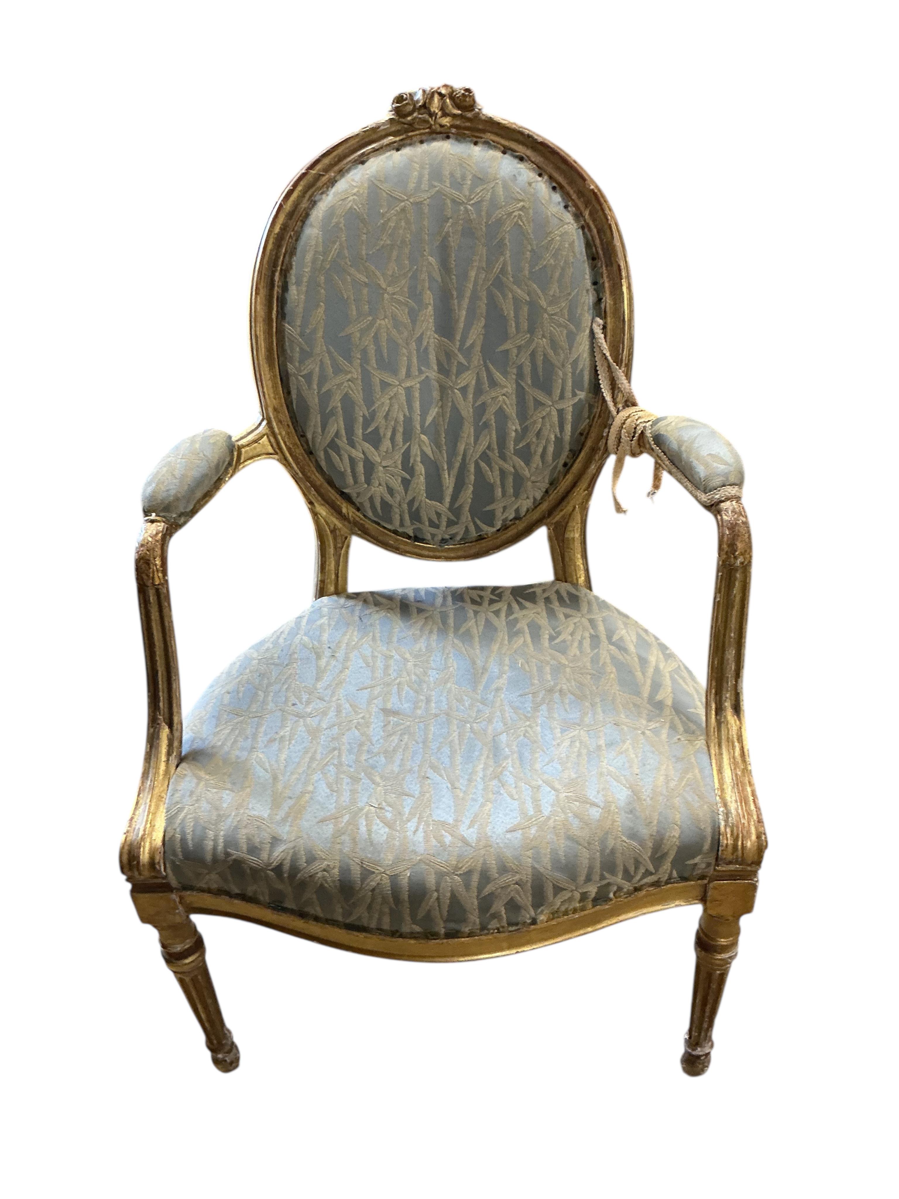 A pair of 18th century carved giltwood open elbow chairs